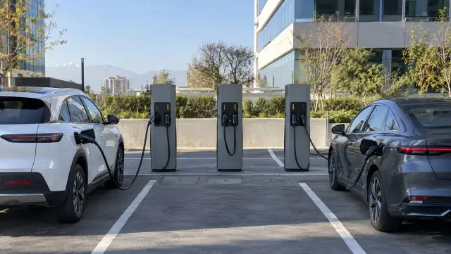 Fila de tres postes de carga en el estacionamiento de un edificio de oficinas